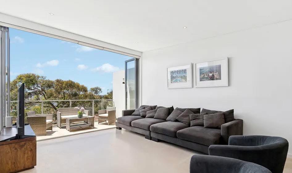 Repainted white living area of a split-level unit opening onto a balcony