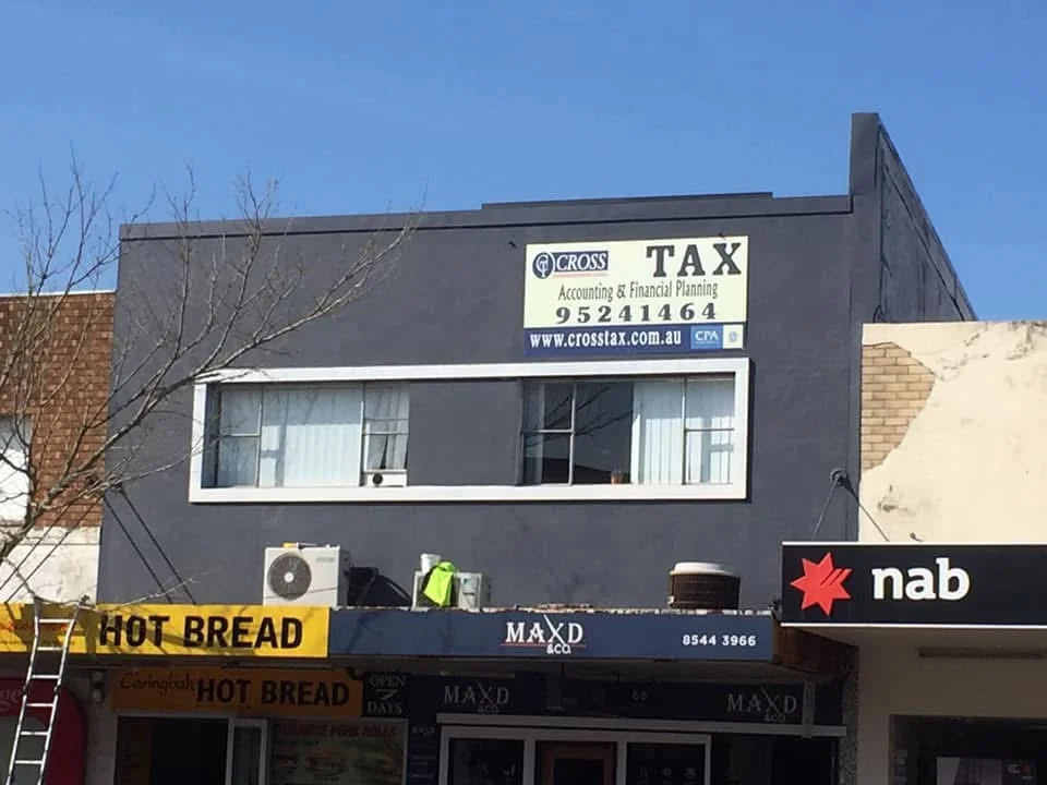 Repainted shopfront with charcoal upper facade and crisp white window surrounds