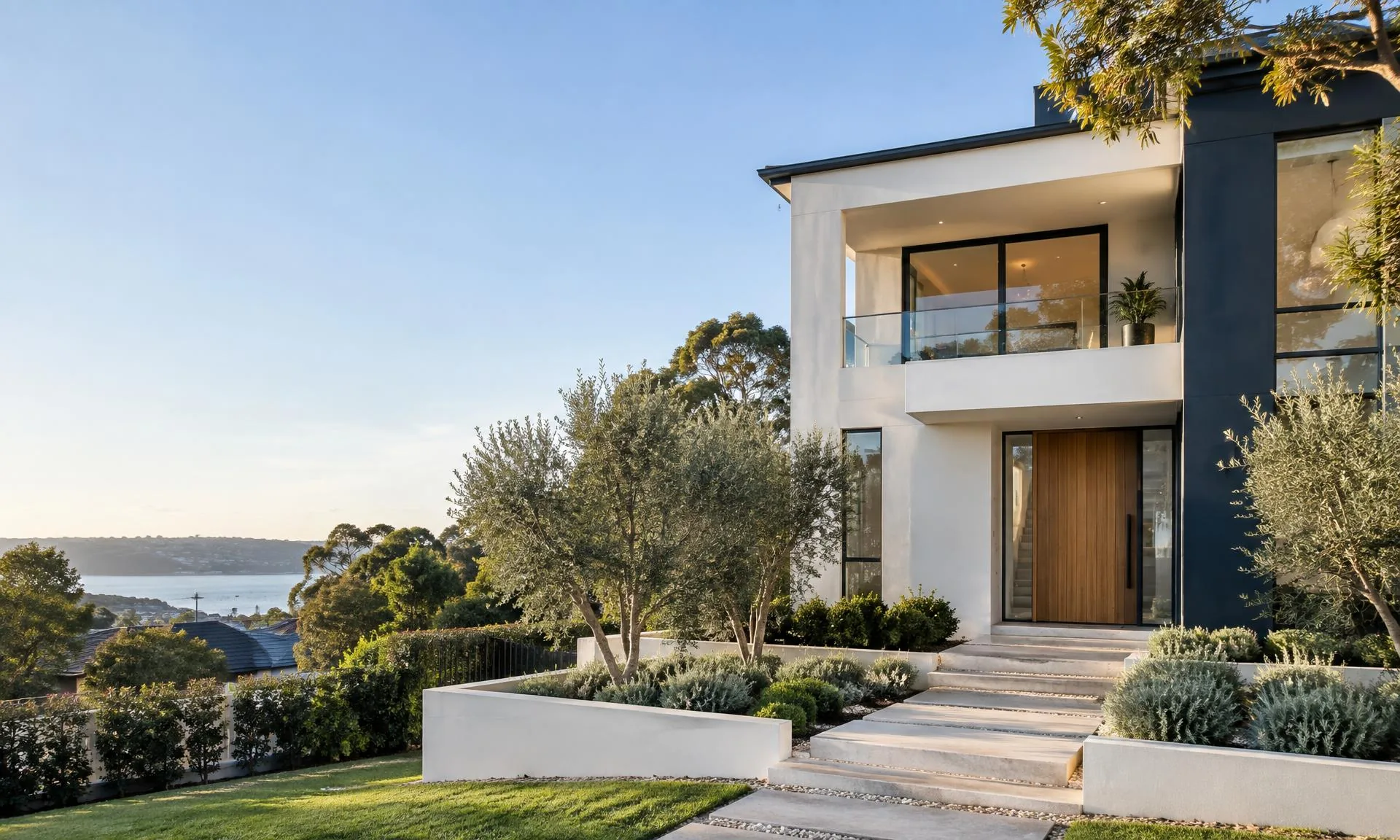 Modern Australian two-storey home with warm white render and navy exterior accents