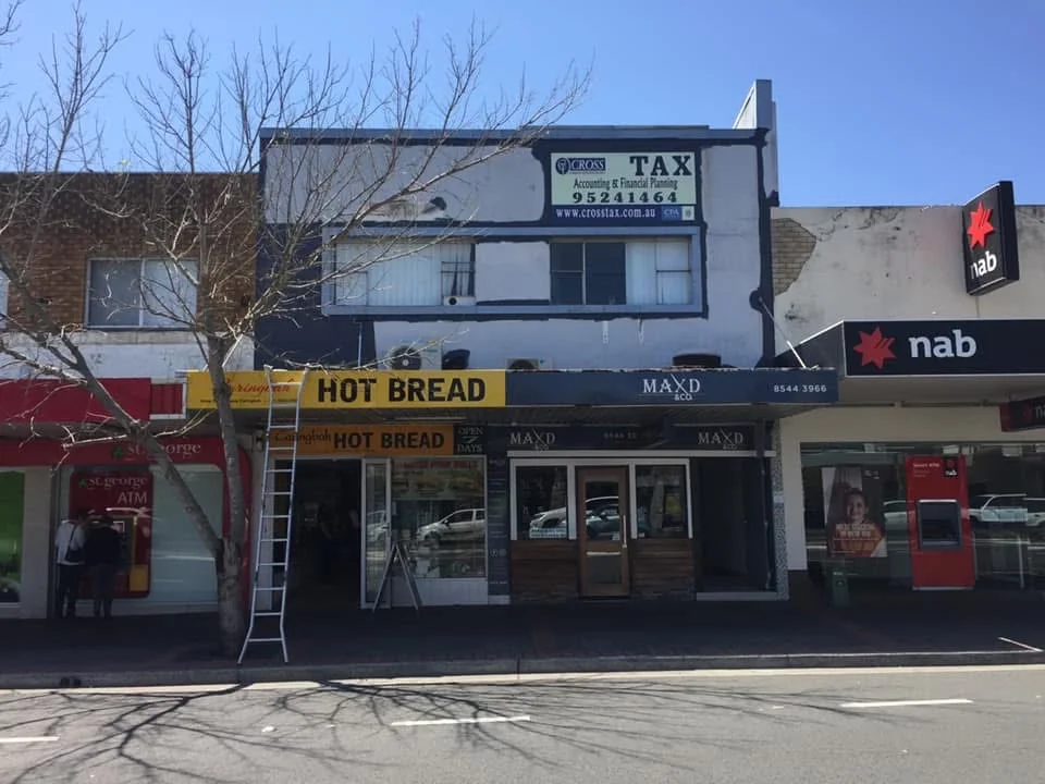 Shopfront before repainting with weathered upper walls and existing dark outlines